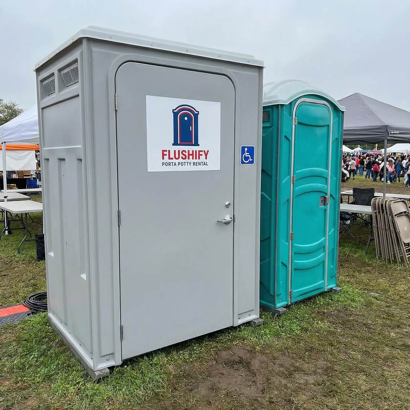 Grey deluxe portable toilet beside a teal unit at an outdoor event